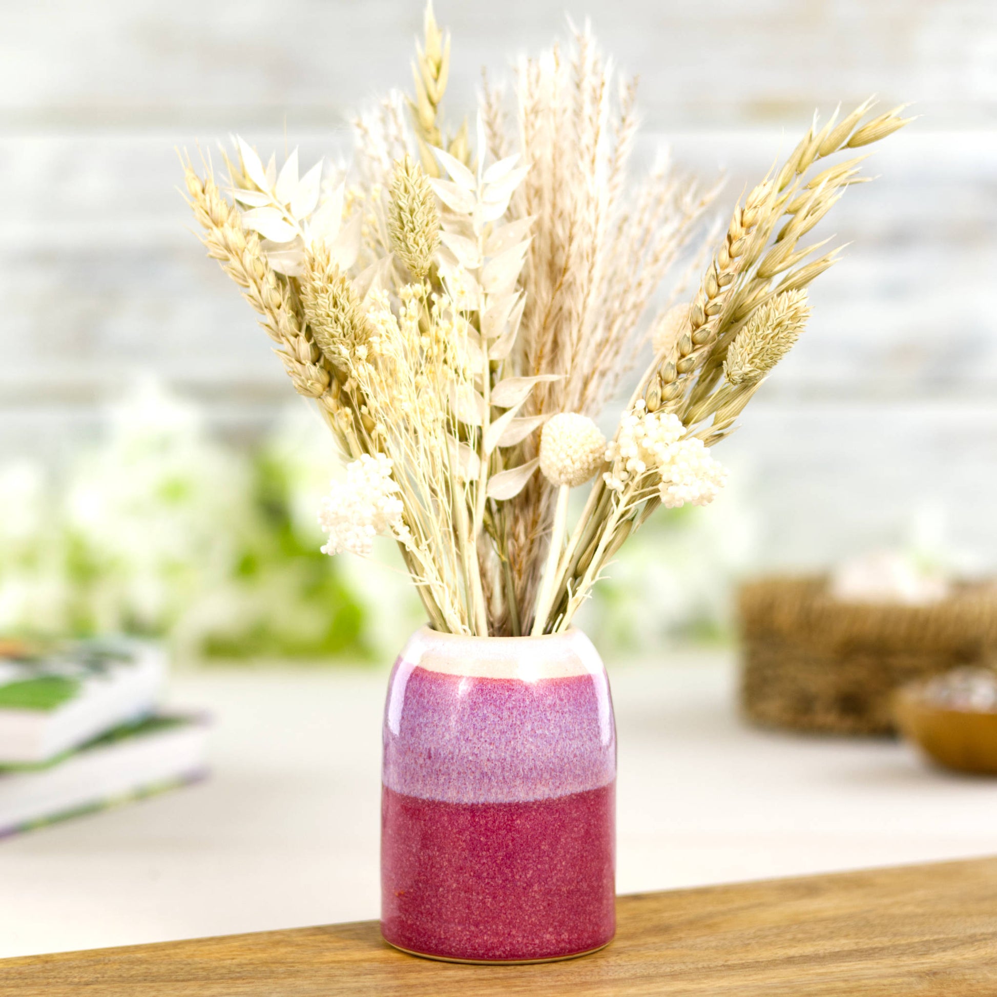 Handmade crimson and white ceramic diffuser vessel repurposed as a bud vase with dried flowers, decorative studio pottery accent