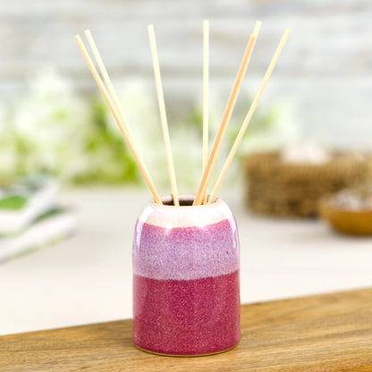 Small wheel-thrown reed diffuser in crimson and white with natural fibre reeds, handmade home scent bottle for contemporary interiors