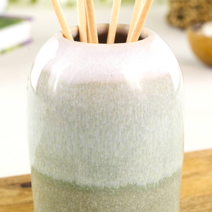 Close-up of flowing layered glazes on a Pale Green and White ceramic reed diffuser with soft speckled finish