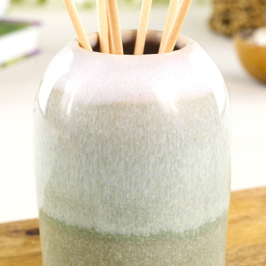 Close-up of flowing layered glazes on a Pale Green and White ceramic reed diffuser with soft speckled finish