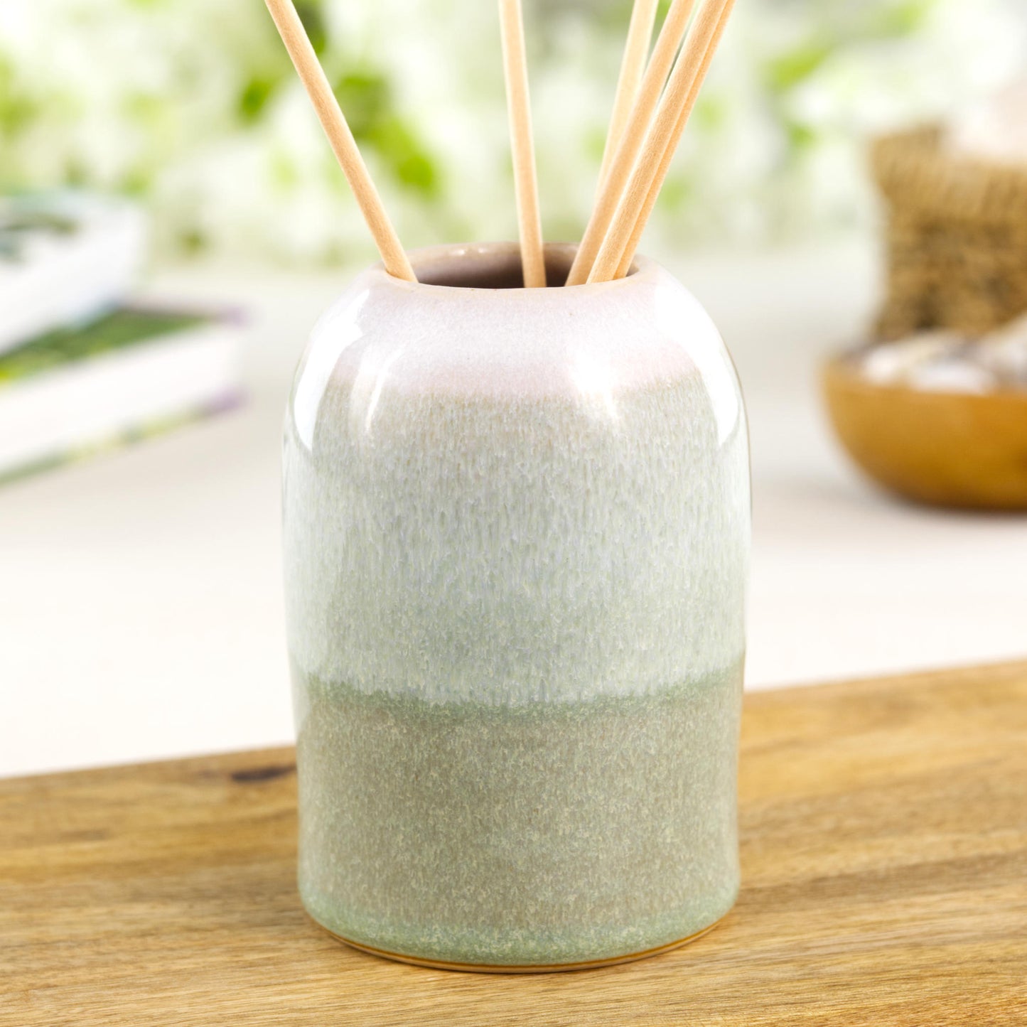 Minimal Pale Green and White stoneware reed diffuser with calming glaze tones on wooden shelf