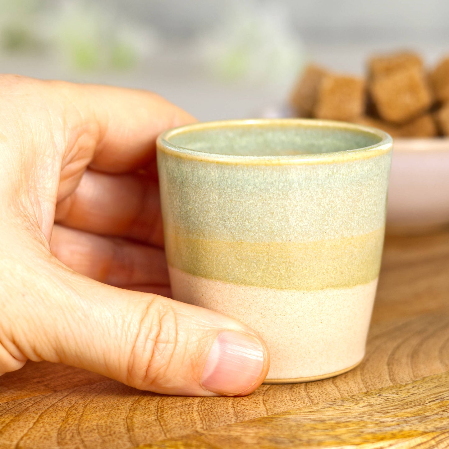 Wheel-thrown stoneware espresso cup in hand showing compact size and comfortable grip