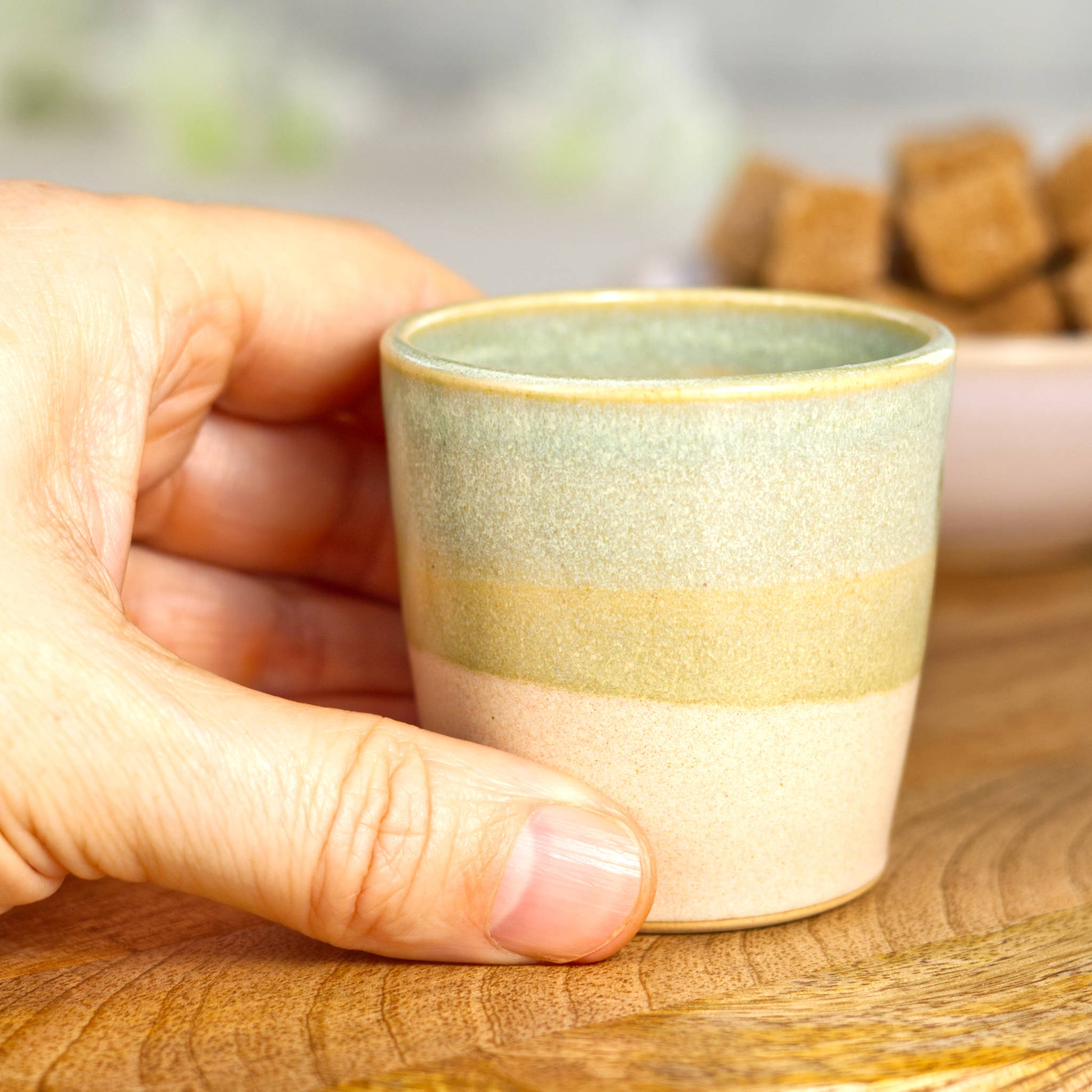 Wheel-thrown stoneware espresso cup in hand showing compact size and comfortable grip