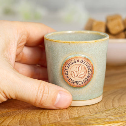 Wheel-thrown stoneware espresso cup in hand showing small espresso size and tactile feel