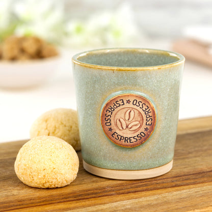 Pale Green ceramic espresso cup with coffee bean motif styled with biscuits on wooden board