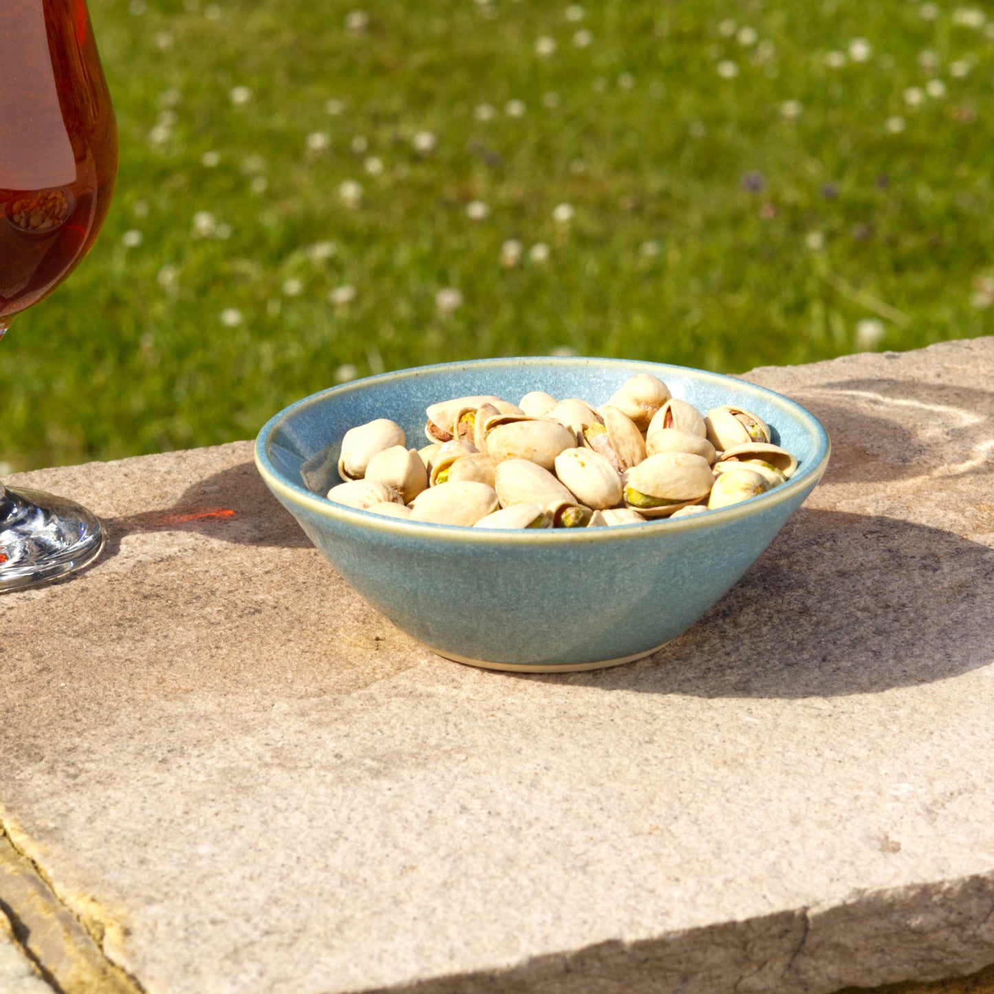 Coastal Blue handmade ceramic snack bowl filled with pistachios on a garden wall, small studio pottery for relaxed nibbles