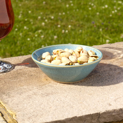 Coastal Blue handmade ceramic snack bowl filled with pistachios on a garden wall, small studio pottery for relaxed nibbles