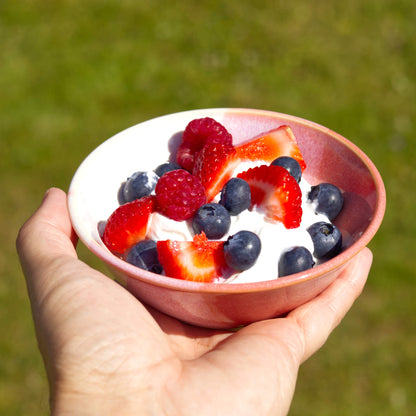Coral and White handmade small bowl filled with yoghurt, strawberries, raspberries and blueberries, a wheel-thrown stoneware breakfast bowl for summer brunch and alfresco dining