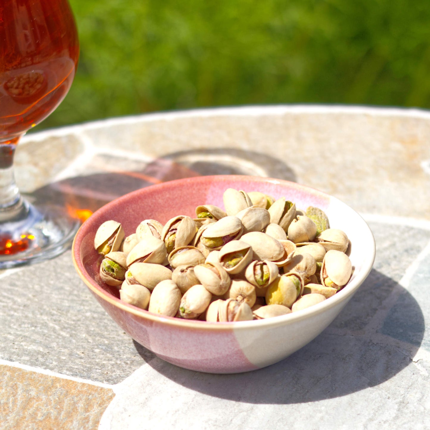 Coral and White ceramic snack bowl with pistachios beside a drink, handmade stoneware nibbles bowl for garden parties, barbecues and relaxed outdoor entertaining