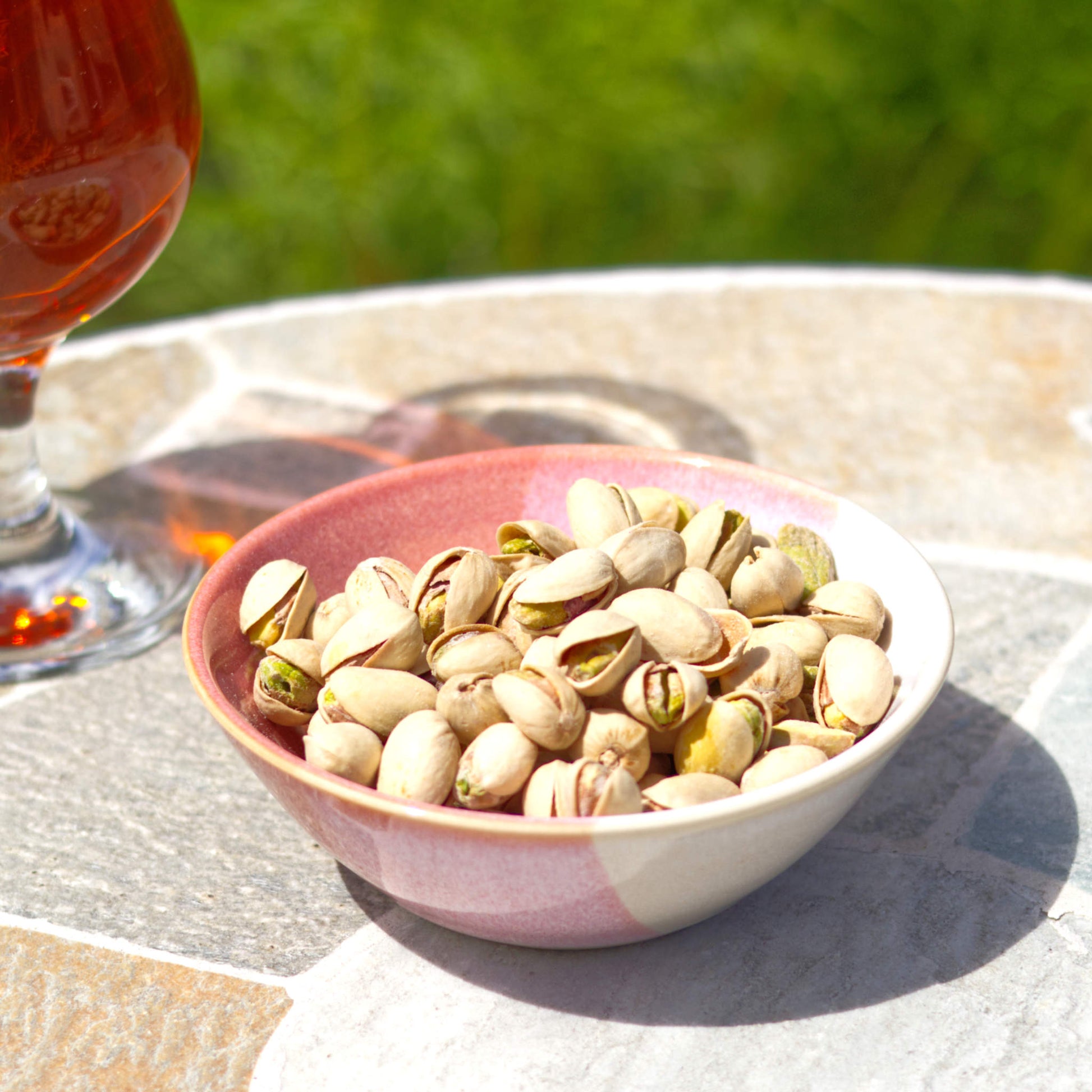 Coral and White ceramic snack bowl with pistachios beside a drink, handmade stoneware nibbles bowl for garden parties, barbecues and relaxed outdoor entertaining