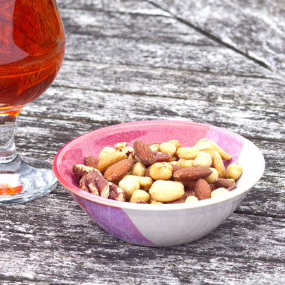 Crimson and White ceramic nibbles bowl filled with mixed nuts beside a drink, handmade stoneware bowl for aperitif snacks, sharing platters and relaxed outdoor entertaining