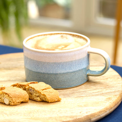 White and Coastal Blue cappuccino cup filled with coffee on round board, handmade ceramic cup for slow mornings and café rituals