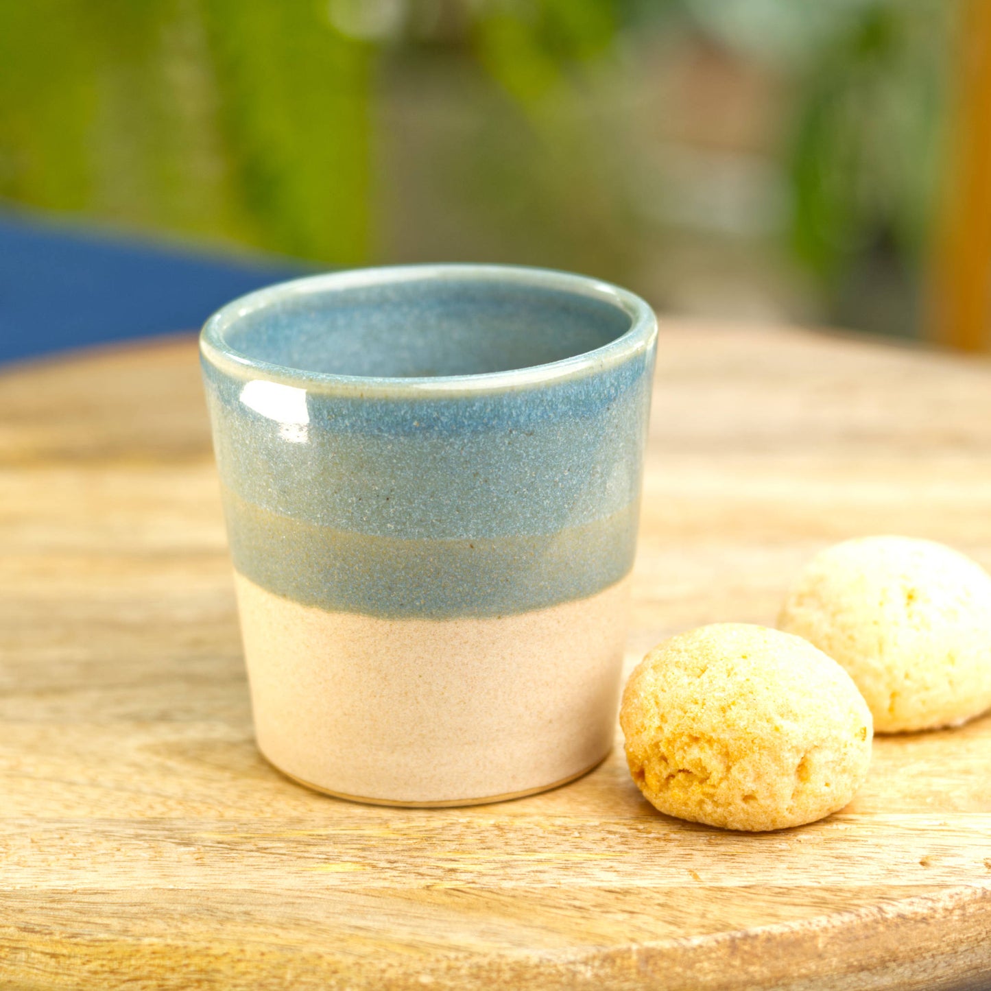 Handmade two-tone espresso cup on table with amaretti biscuits for café style coffee at home