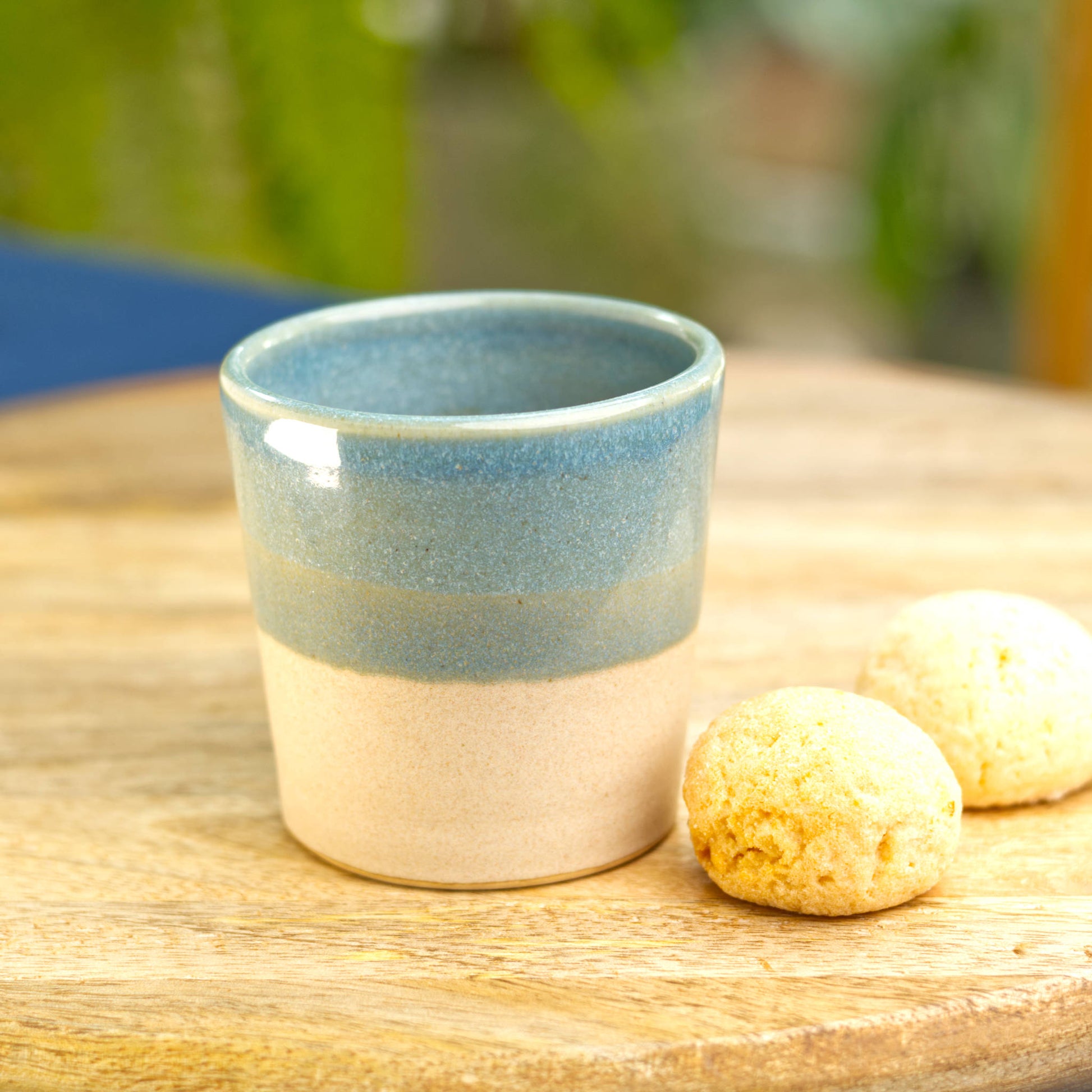 Handmade two-tone espresso cup on table with amaretti biscuits for café style coffee at home