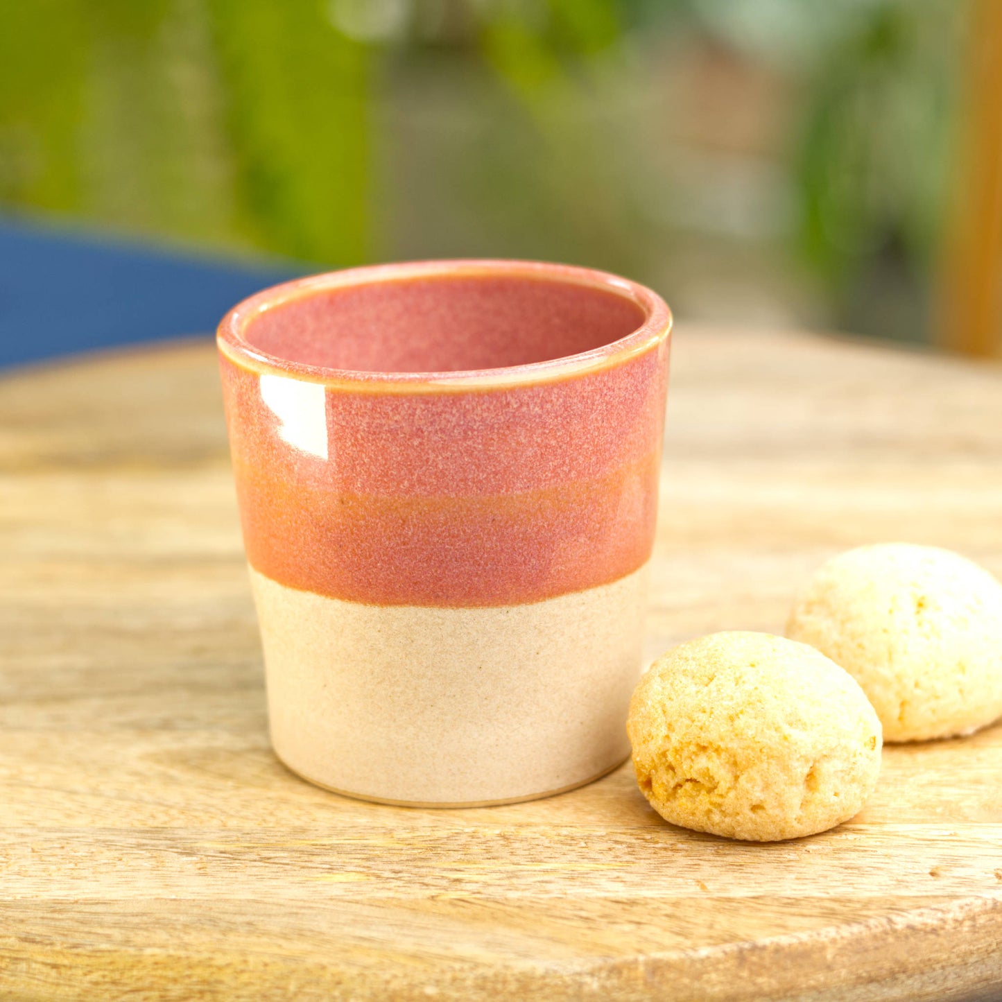 Handmade ceramic espresso cup on table with biscuits for warm, relaxed coffee moment