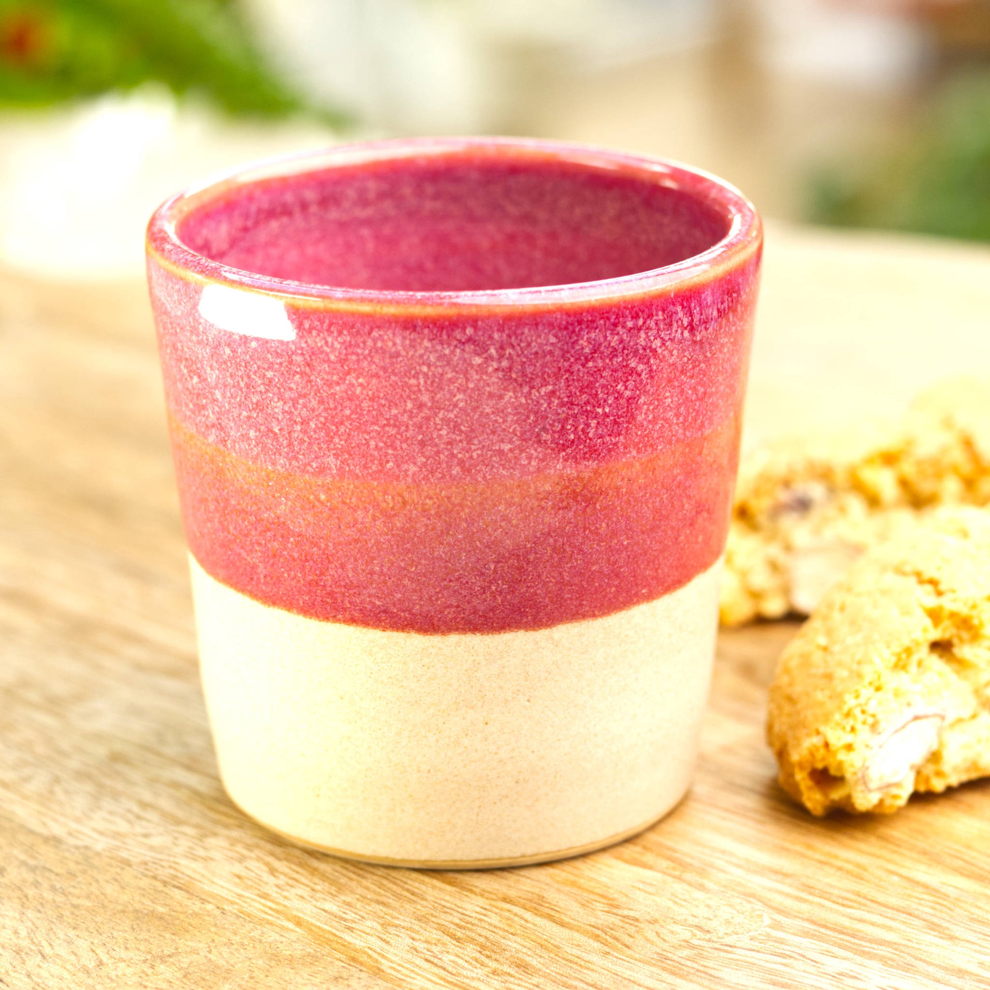 Crimson two-tone espresso cup styled with biscotti for after dinner coffee moment