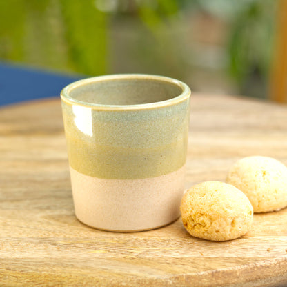 Handmade ceramic espresso cup on table with biscuits for relaxed morning coffee at home