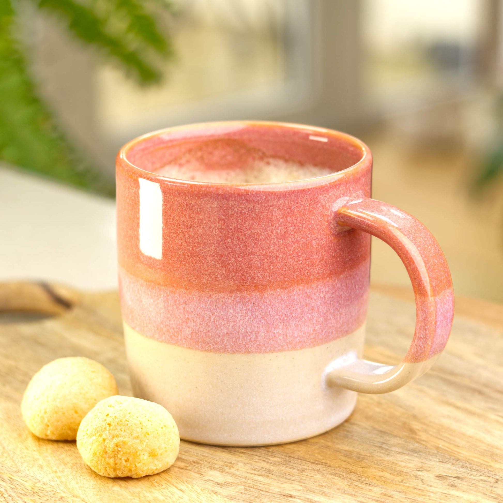 Coral and White handmade mug filled with coffee in a kitchen setting, an artisan pottery mug with a calm café-at-home feel