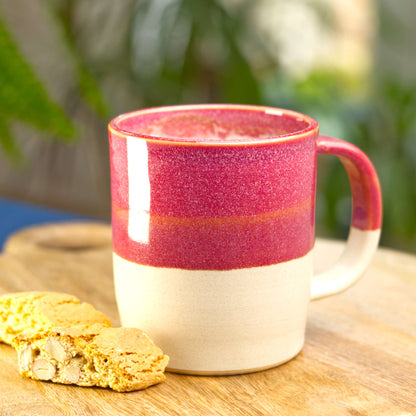 Crimson and Sand handmade coffee mug filled with frothy latte on a wooden board with biscotti, wheel-thrown stoneware from my Sussex pottery studio