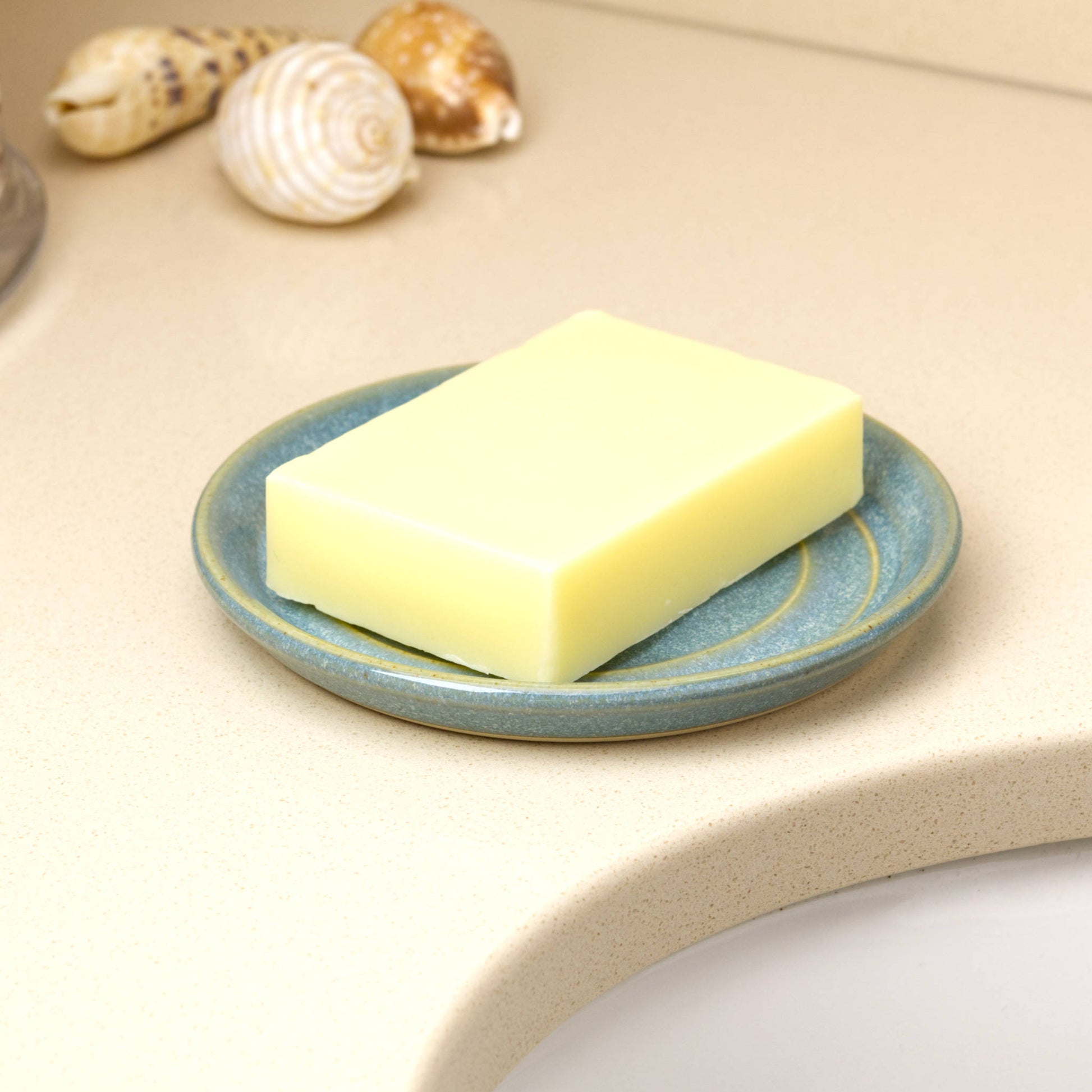 Coastal Blue ceramic soap holder with cream soap bar, wheel-thrown handmade soap tray beside basin in modern bathroom