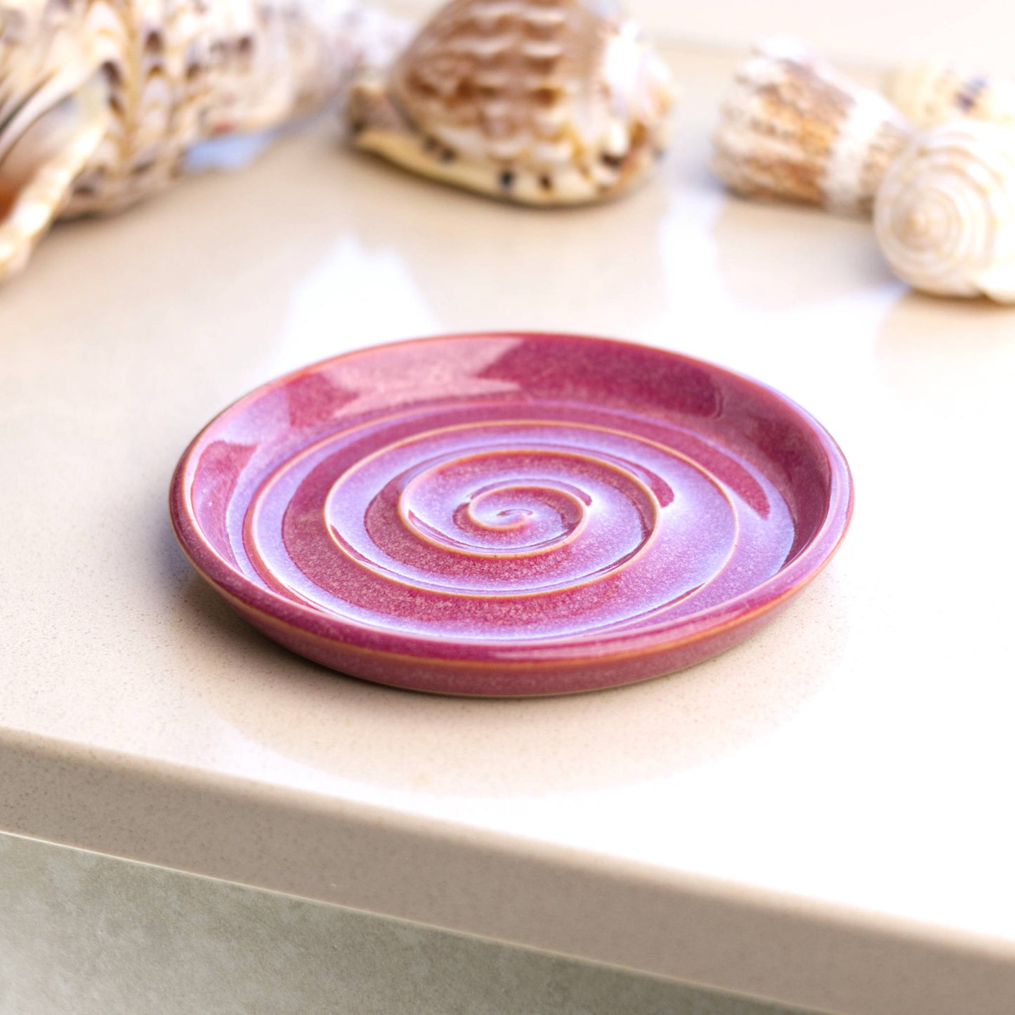 Crimson ceramic soap dish on bathroom windowsill, handmade spiral soap holder adding warm colour to modern bathroom décor