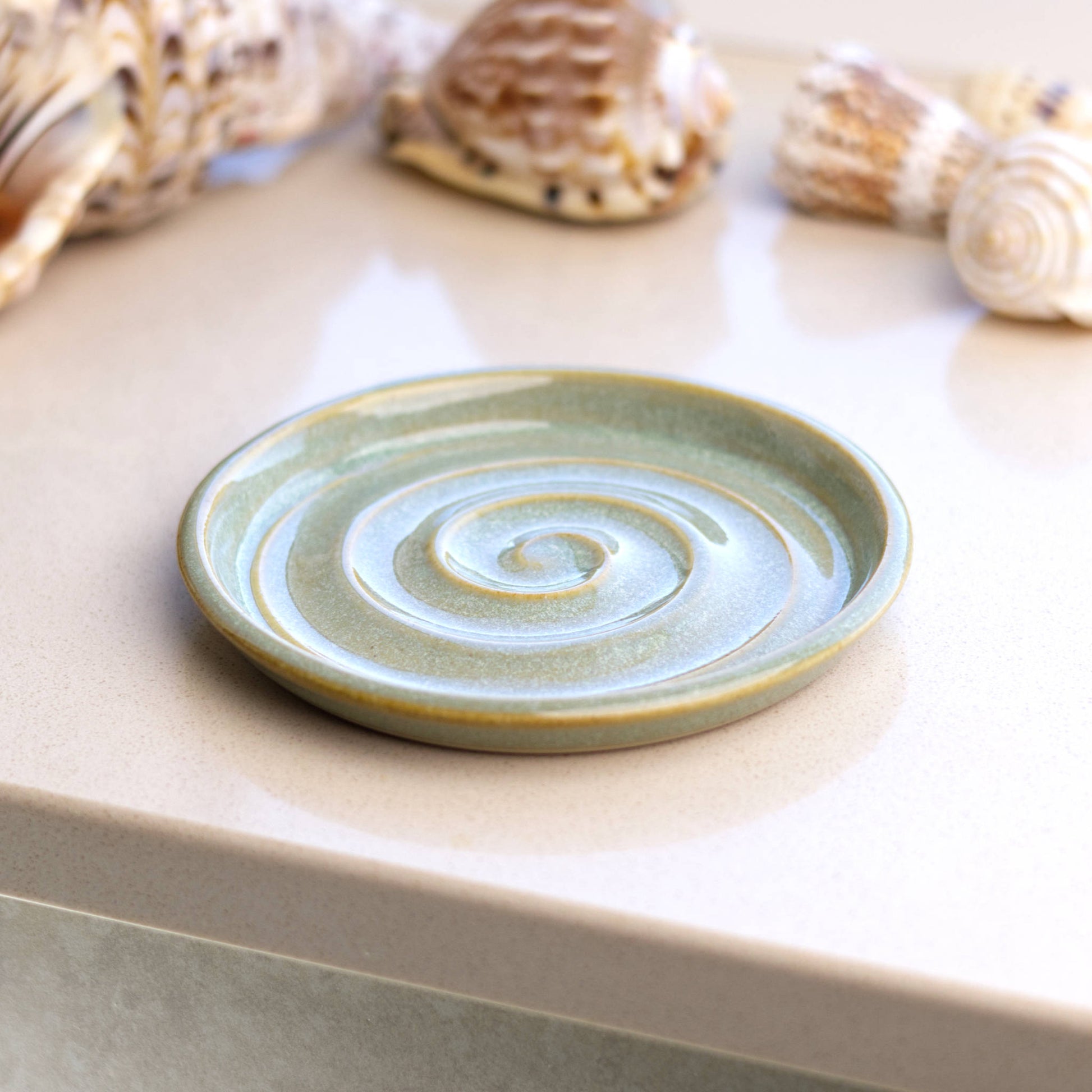 Pale green handmade soap holder on bathroom windowsill with coastal styling