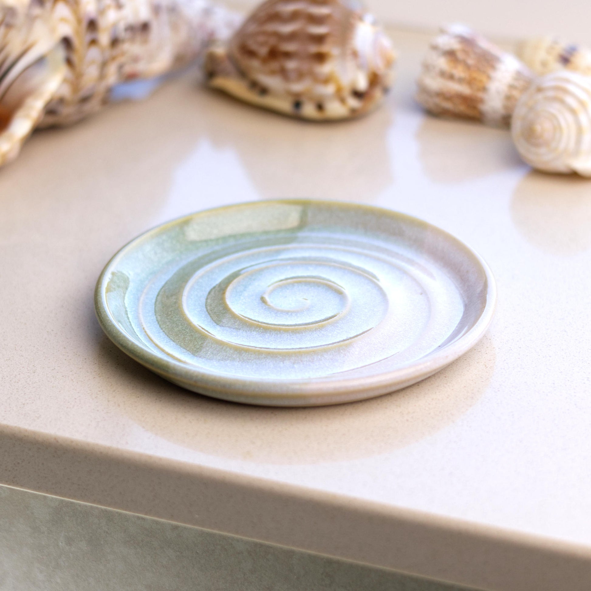 Pale green and white ceramic soap tray on bathroom windowsill, handmade coastal decor soap dish with soft layered glazes
