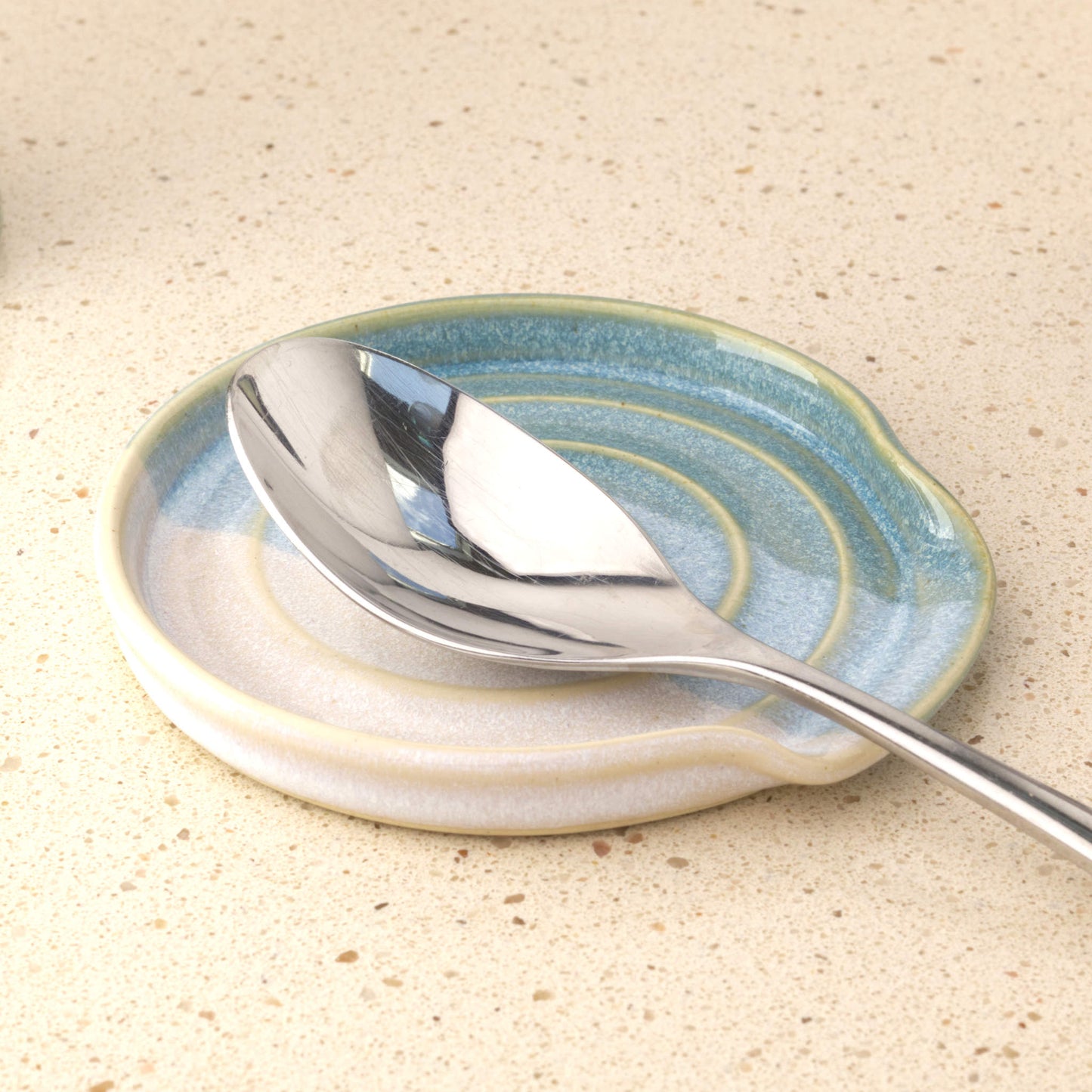 Coastal Blue and White ceramic spoon rest holding serving spoon, practical handmade kitchen accessory for tidy worktops