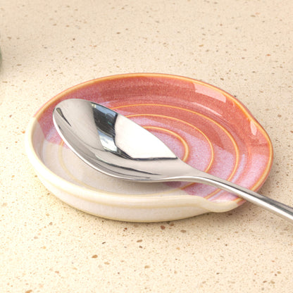 Coral and White ceramic spoon rest holding serving spoon, practical handmade kitchen accessory for clean worktops