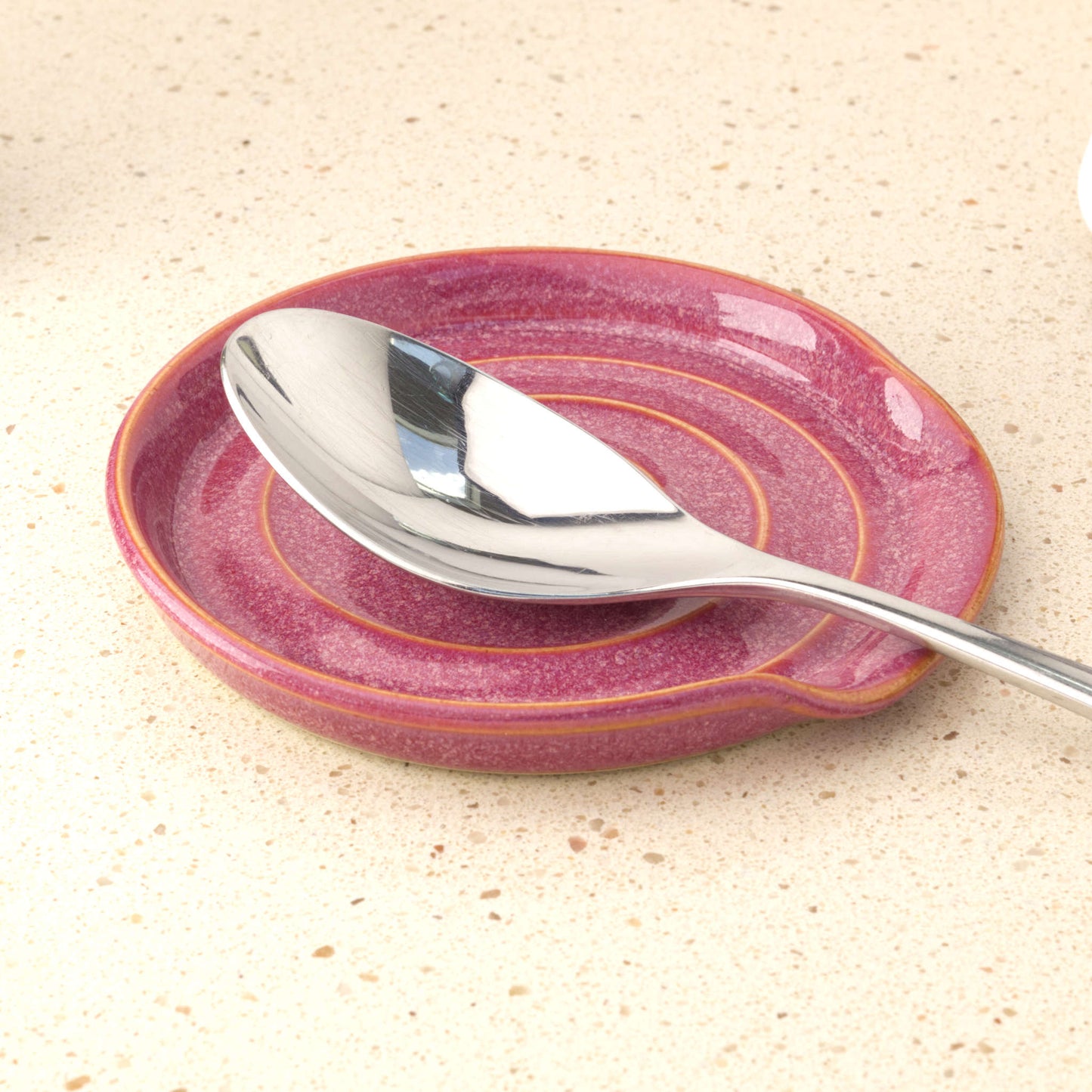 Crimson handmade ceramic spoon rest holding tablespoon, practical stoneware utensil rest for cooking splashes and tidy worktops