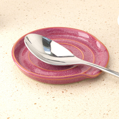 Crimson handmade ceramic spoon rest holding tablespoon, practical stoneware utensil rest for cooking splashes and tidy worktops