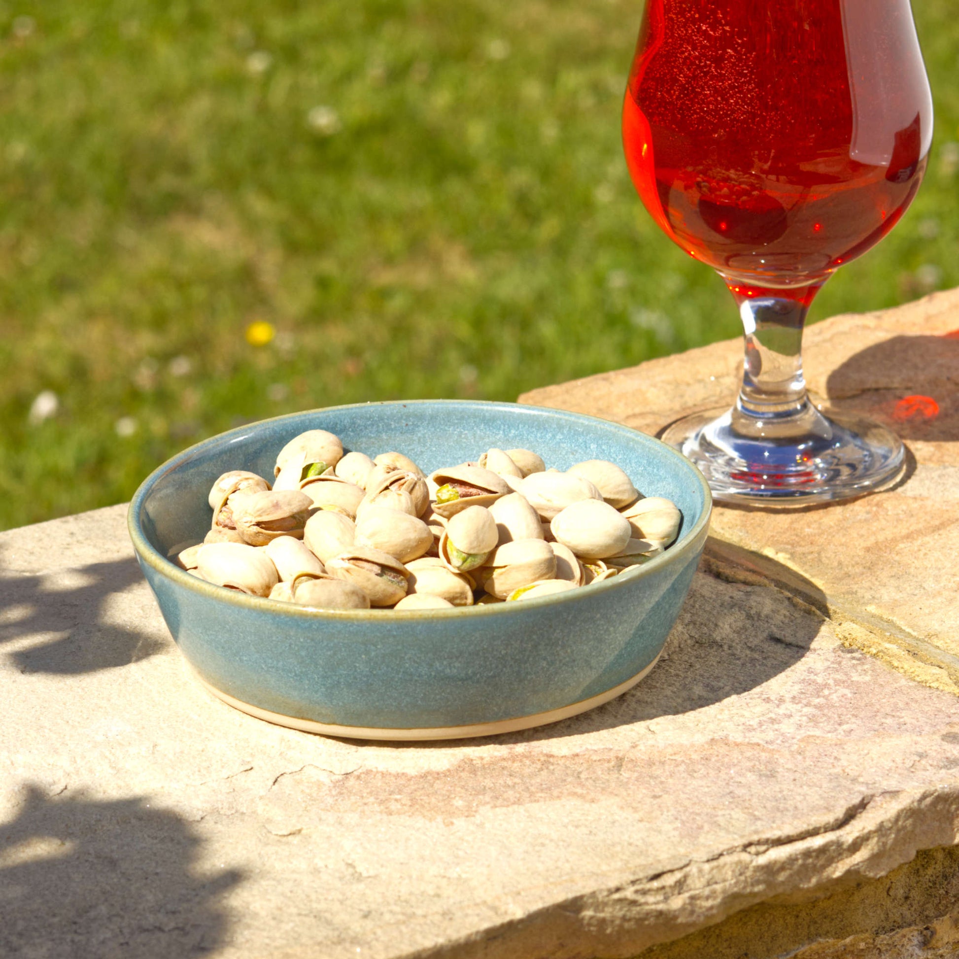 Coastal Blue handmade tapas bowl filled with pistachios, styled outdoors for aperitif snacks, nibbles, garden entertaining and relaxed summer sharing