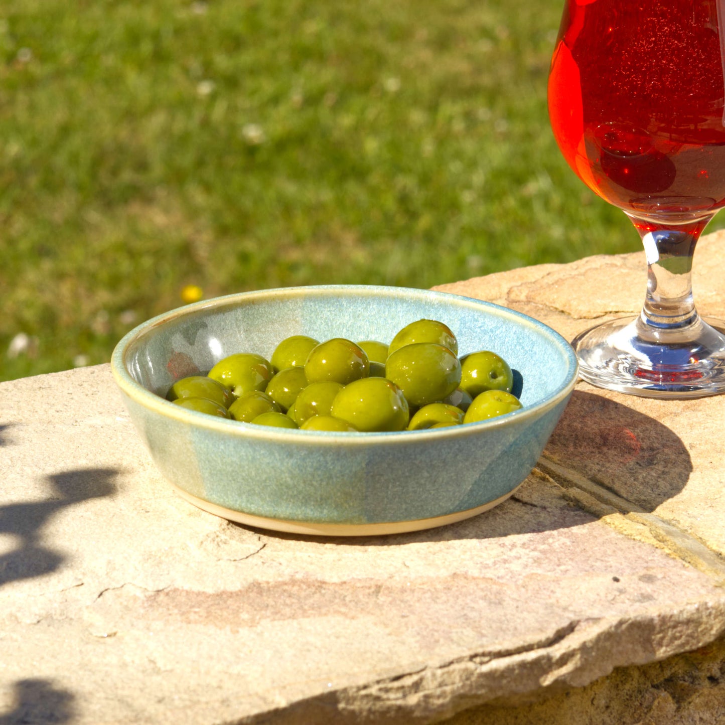 Coastal Blue & Pale Green handmade tapas bowl filled with olives, styled outdoors for aperitif snacks, antipasti, Mediterranean nibbles and relaxed garden entertaining