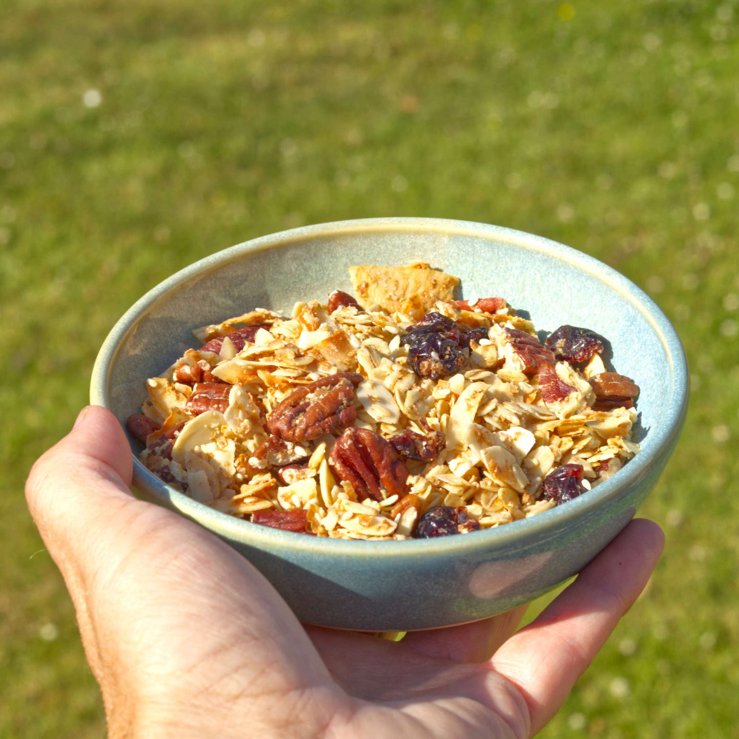 Handmade Coastal Blue & Pale Green ceramic tapas bowl held in the hand and filled with granola, a versatile small stoneware bowl for light breakfasts, brunch and alfresco summer dining