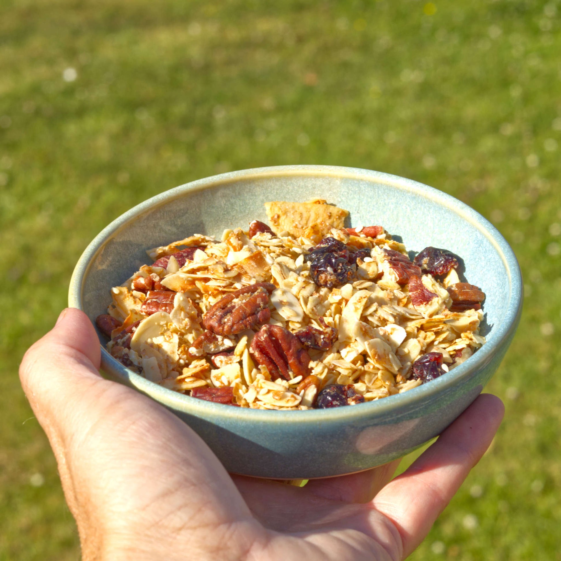 Handmade Coastal Blue & Pale Green ceramic tapas bowl held in the hand and filled with granola, a versatile small stoneware bowl for light breakfasts, brunch and alfresco summer dining