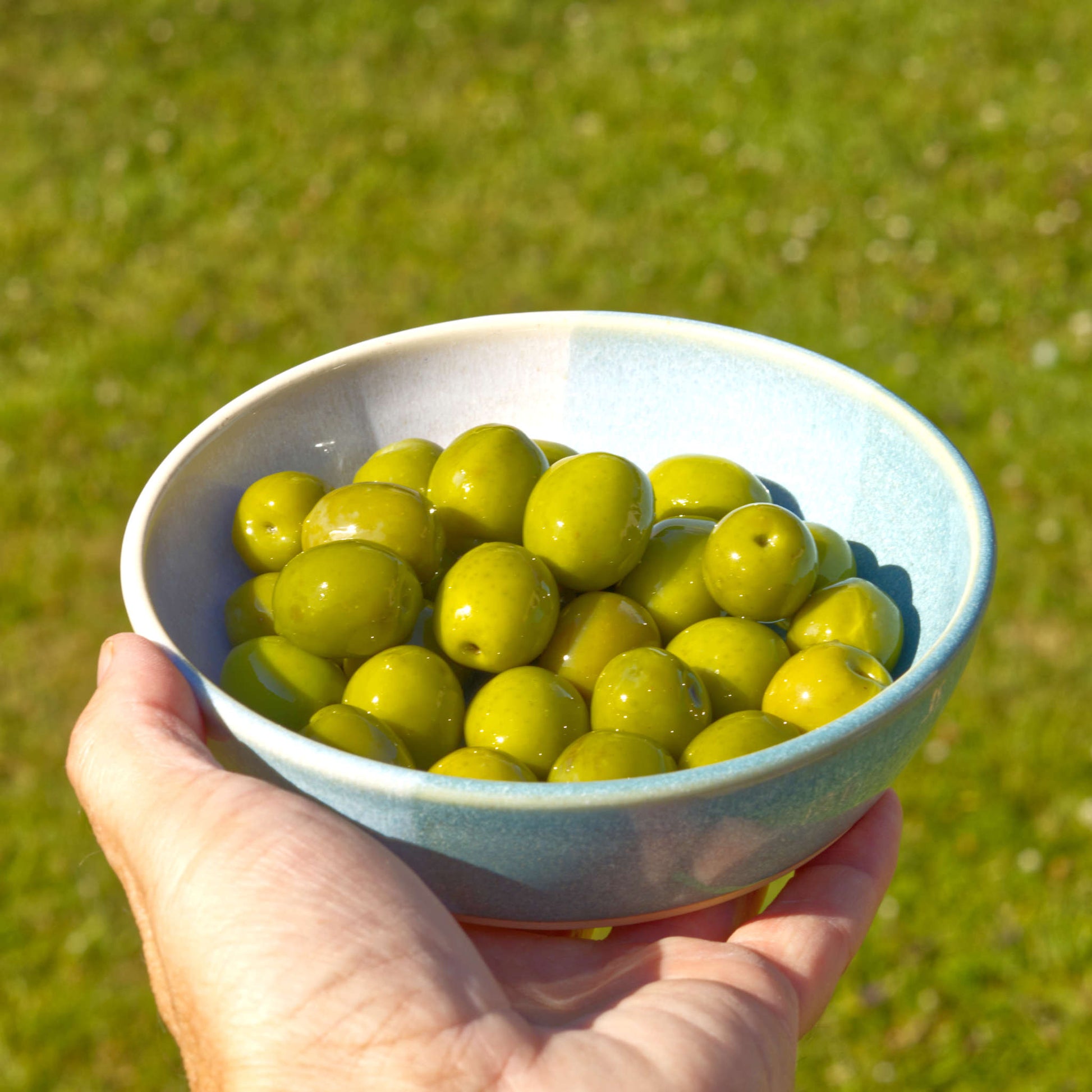 Handmade Coastal Blue & White tapas bowl held in the hand and filled with olives, ideal for mezze, appetisers and Mediterranean-style outdoor entertaining