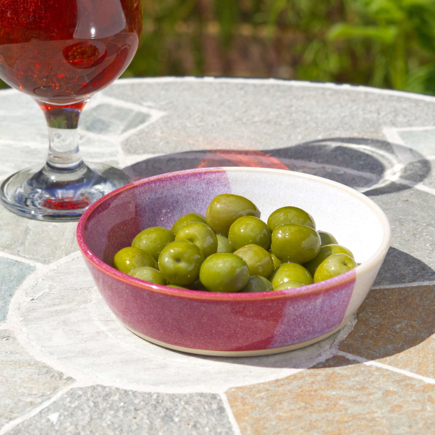 Crimson & White stoneware tapas bowl filled with olives beside a drink, perfect for antipasti, nibbles, aperitif snacks and Mediterranean-style outdoor dining
