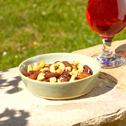 Pale Green handmade tapas bowl filled with mixed nuts, styled outdoors for aperitif snacks, party nibbles, grazing boards and relaxed garden entertaining