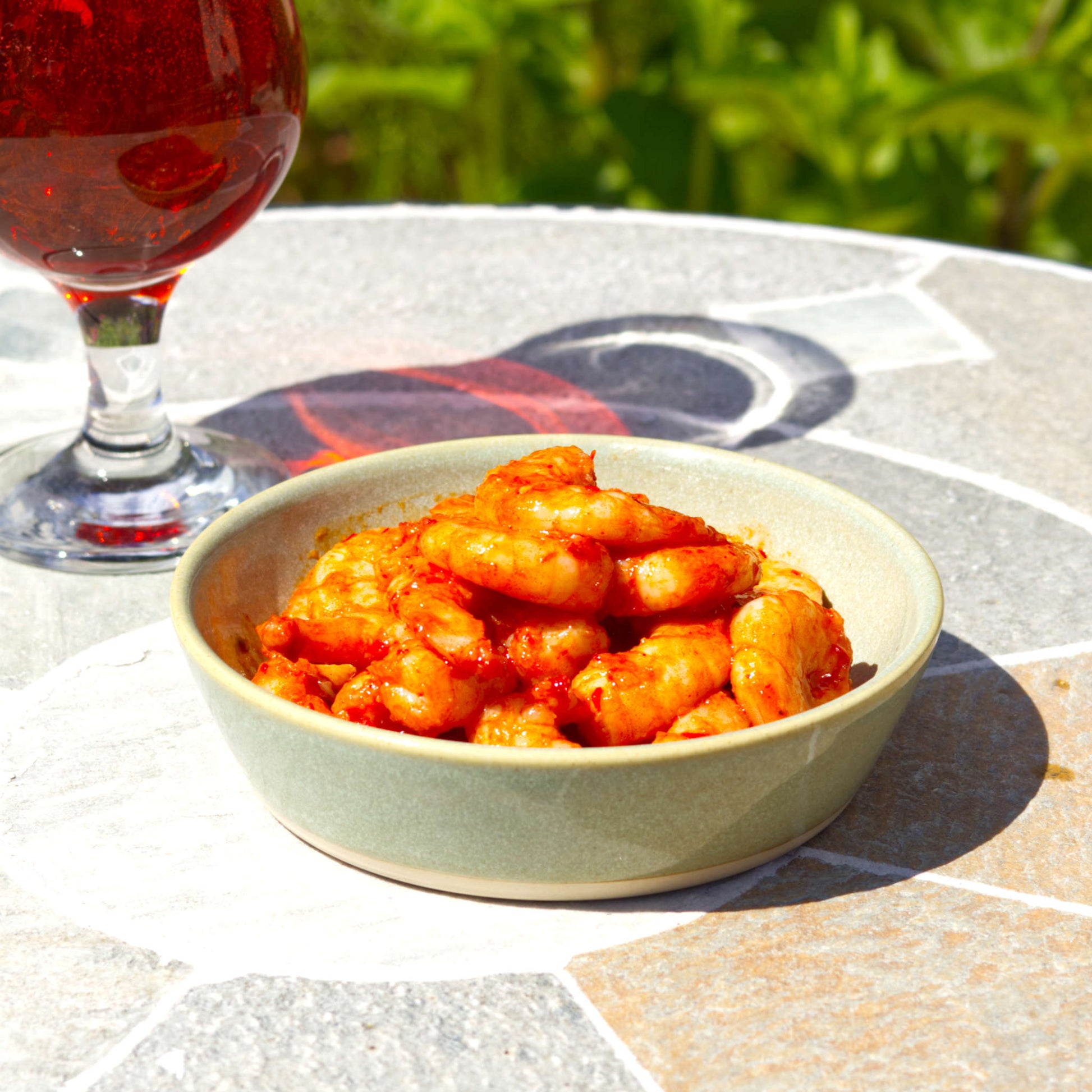 Handmade Pale Green ceramic tapas bowl served with prawns beside a drink, a shallow stoneware dish for seafood starters, small plates and alfresco summer dining