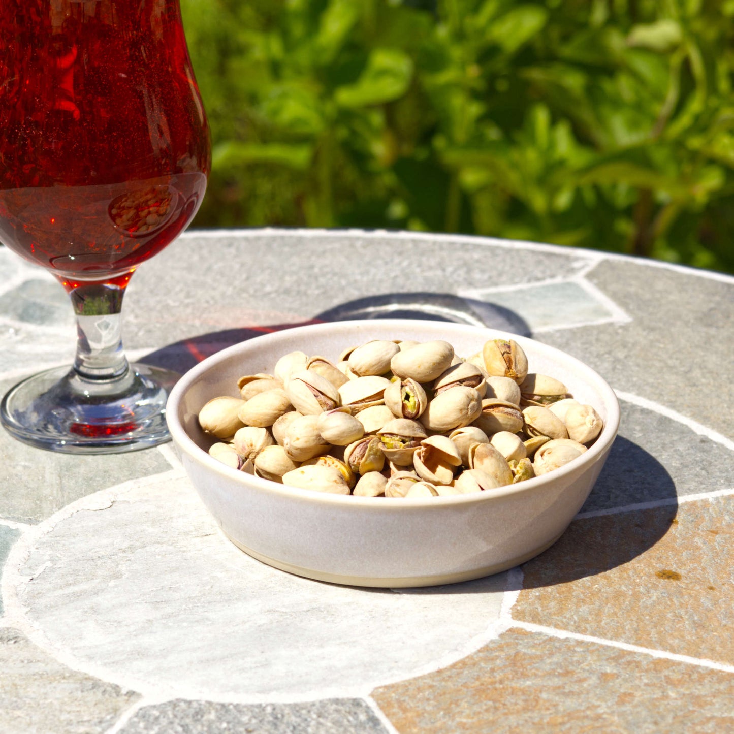 Handmade white stoneware tapas bowl filled with pistachios beside a drink, perfect for aperitif snacks, bar nibbles, Scandi-style tableware and outdoor sharing food