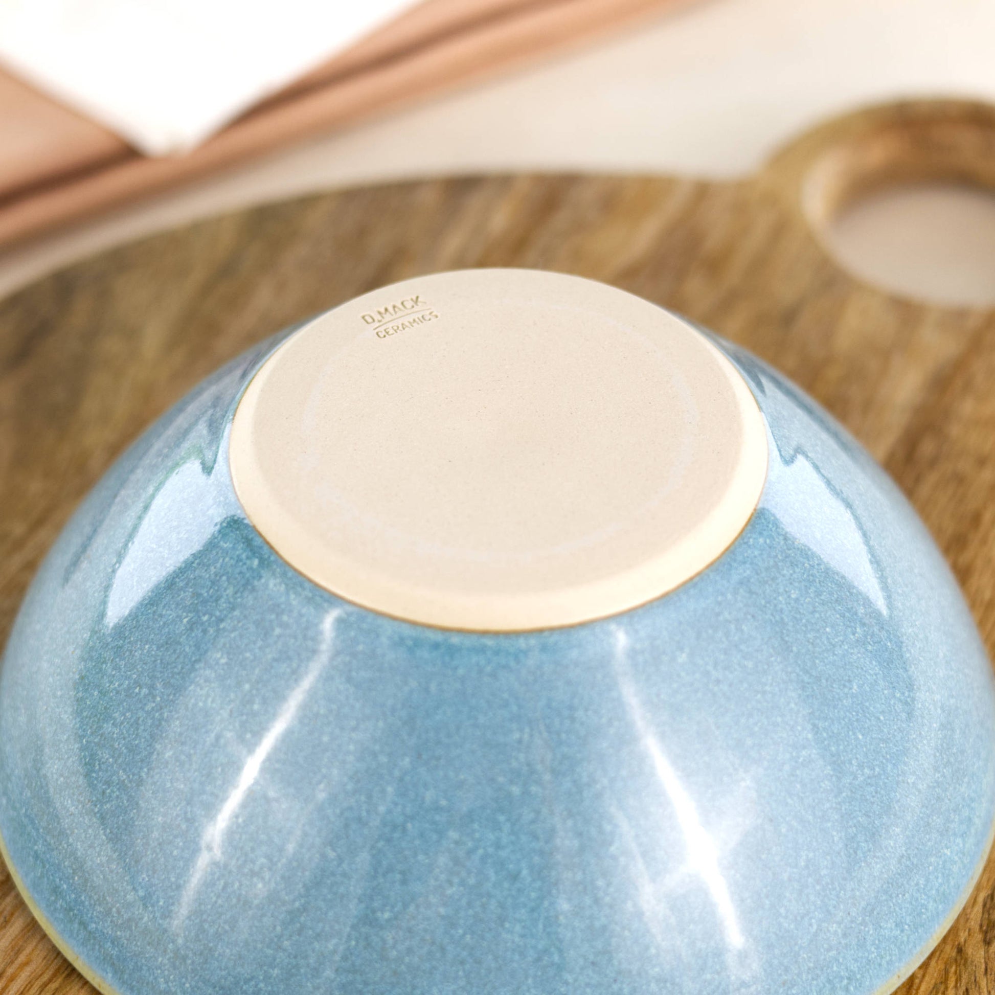 Base of a wheel-thrown medium pottery bowl in Coastal Blue, showing the D Mack Ceramics makers mark and smooth burnished foot, handmade in a Sussex studio