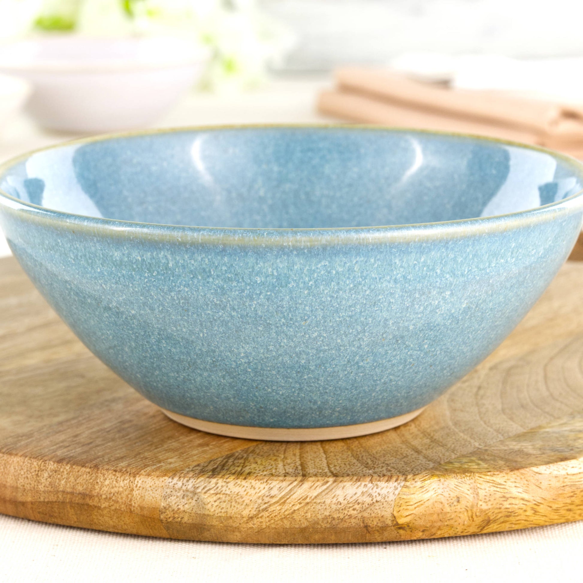 Close-up of a handmade stoneware bowl in Coastal Blue, highlighting the glossy speckled glaze, soft ceramic texture and artisan studio finish
