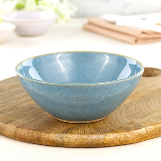 Wheel-thrown Coastal Blue medium bowl on a wooden board, a colourful piece of British studio pottery for pasta, salads and relaxed handmade tableware