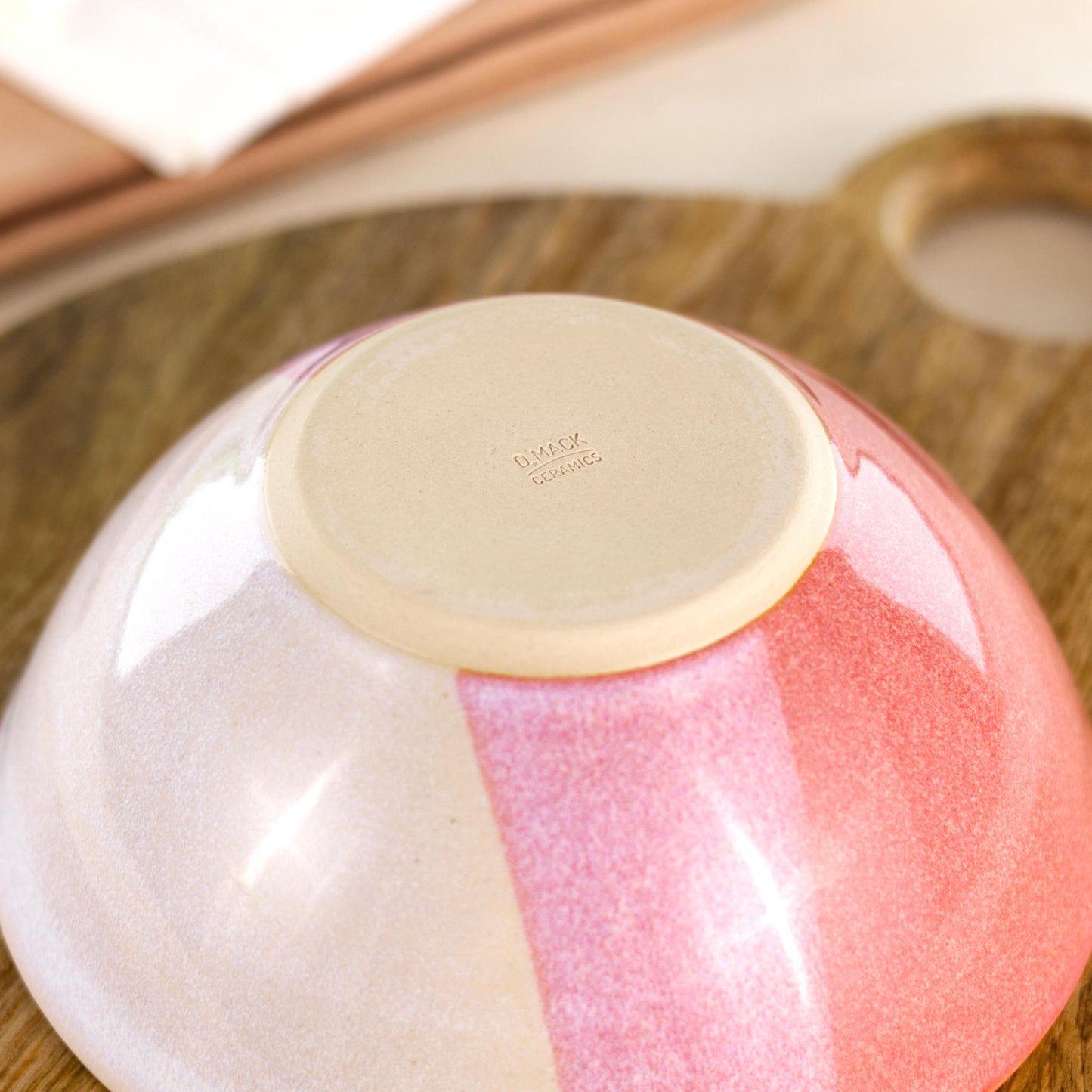 Base of Coral and White handmade medium bowl showing my maker’s mark and smooth burnished foot, designed to help reduce surface scratching