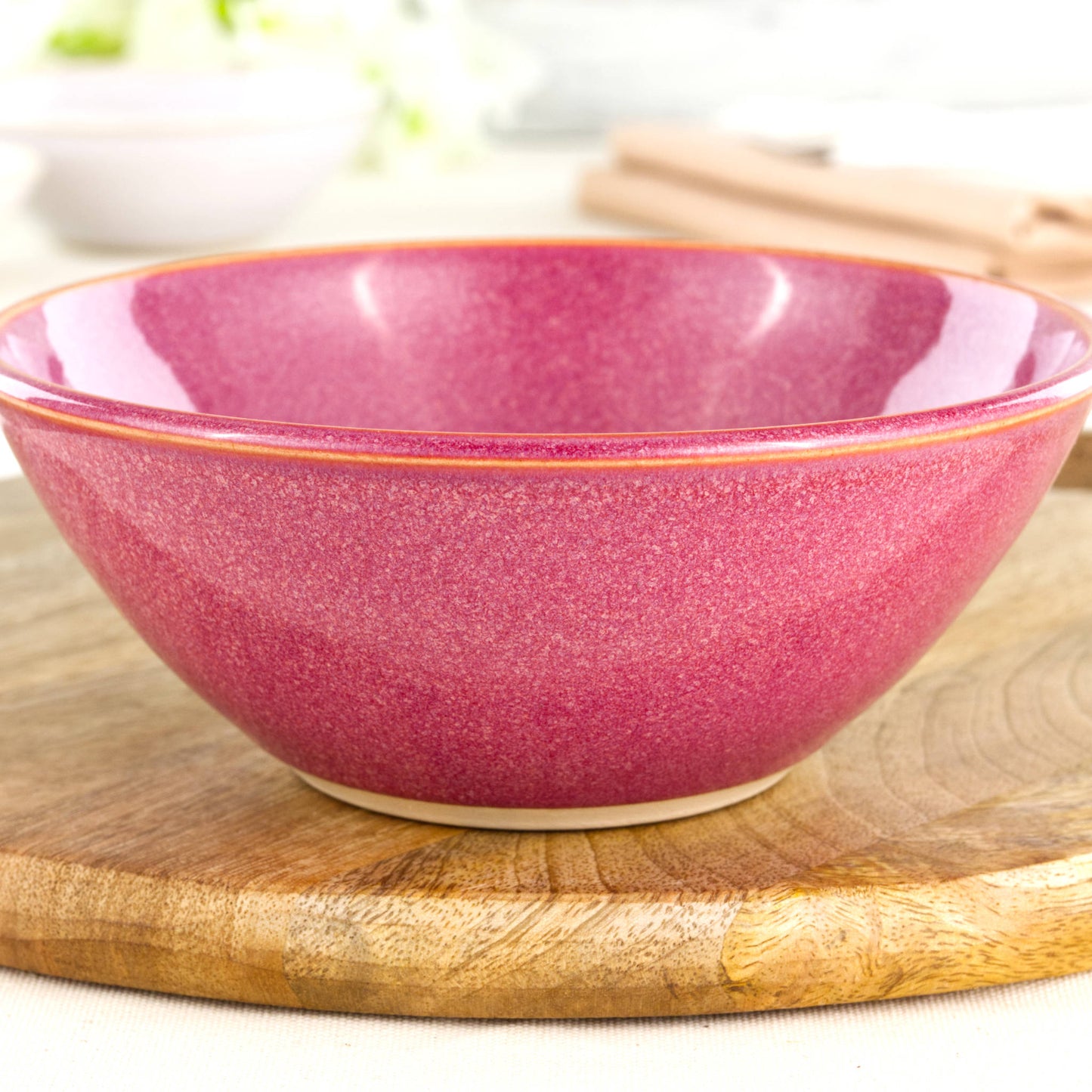 Close-up of a handmade ceramic bowl in Crimson, featuring a rich glossy red glaze, fine speckling and the tactile finish of artisan studio pottery