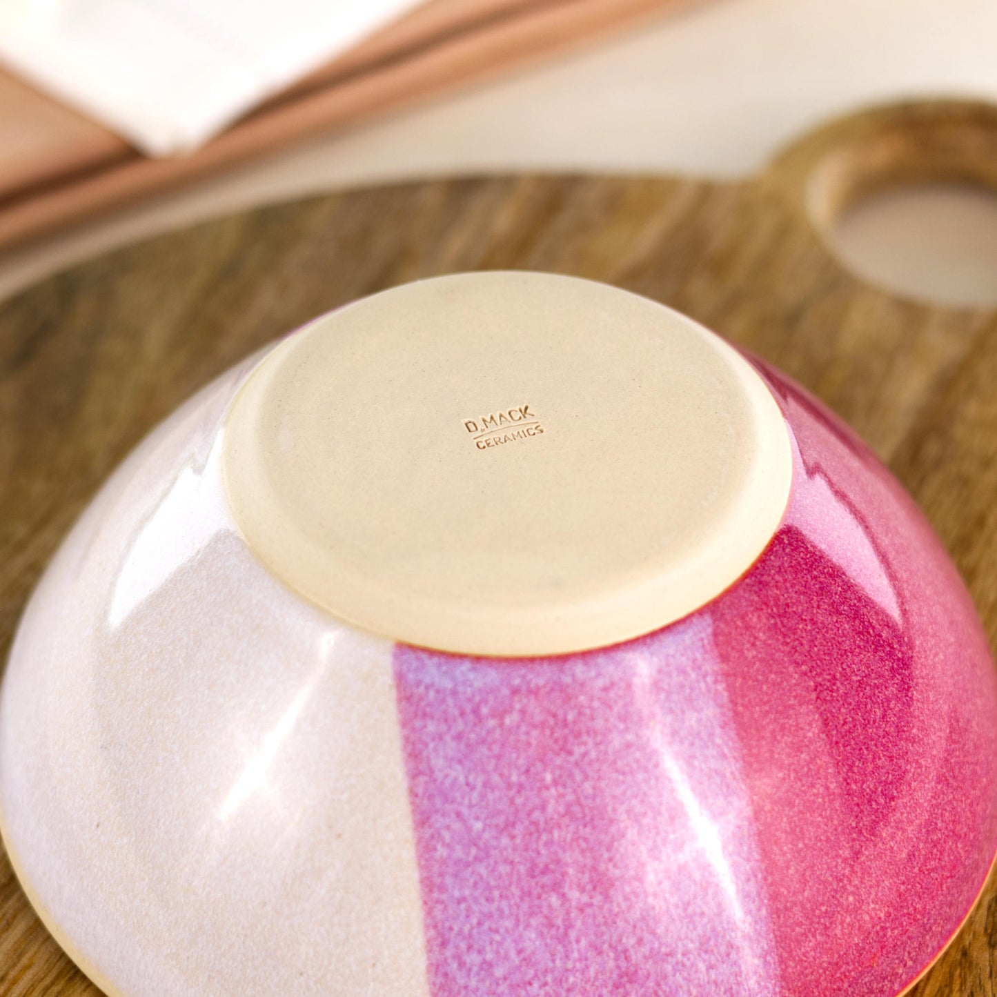 Base of a wheel-thrown medium ceramic bowl in Crimson & White, showing the D Mack Ceramics makers mark and smooth burnished foot to help reduce surface scratching