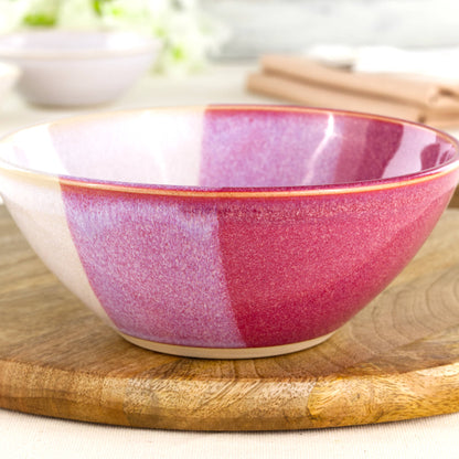 Close-up of a handmade stoneware bowl in Crimson & White, with glossy layered red and soft white glazes across a gently curved medium pottery bowl