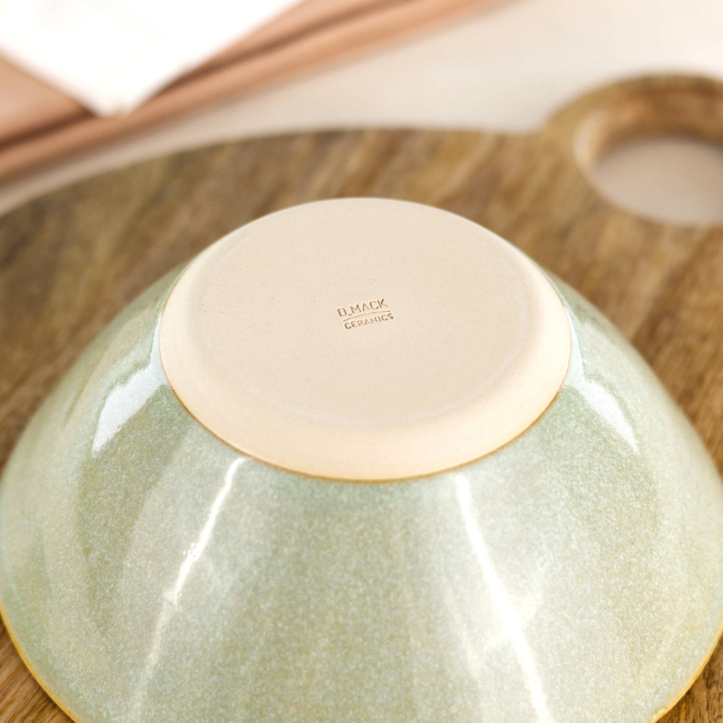 Base of a handmade medium pottery bowl in Pale Green, with the D Mack Ceramics makers mark and smooth burnished foot, made in a small Sussex studio