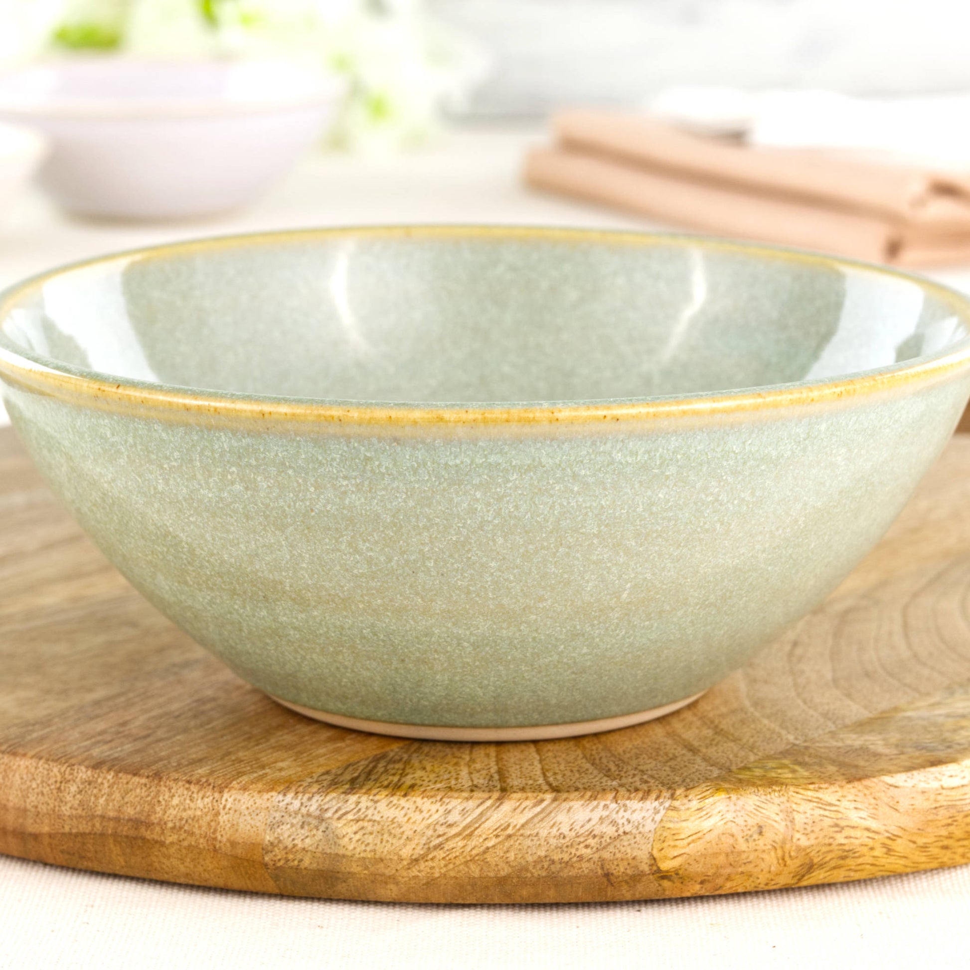 Close-up of a wheel-thrown stoneware bowl in Pale Green, showing the glossy speckled glaze, soft green ceramic finish and artisan studio craftsmanship
