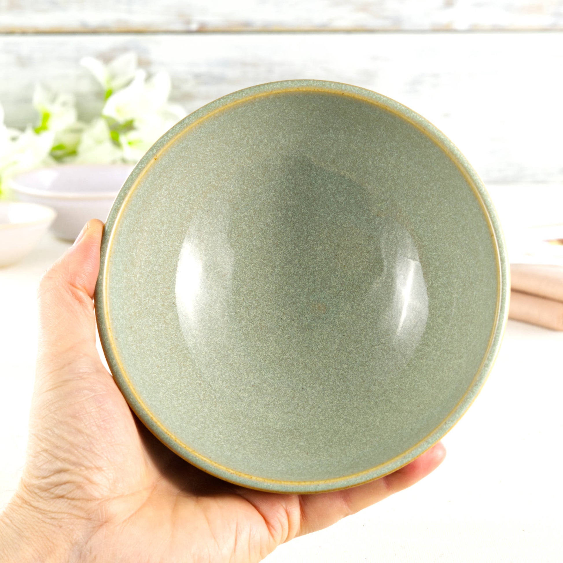 Medium ceramic bowl held in the hand, glazed in Pale Green with a fresh garden-inspired feel, ideal for breakfast, rice bowls or everyday handmade tableware